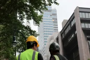 Construction workers gather outside the former Pfizer headquarters in New York City on July 7, 2026, after the building was evacuated following the failure of several steel columns.