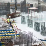A large construction project where the worker is standing on the building in Long Island, NY