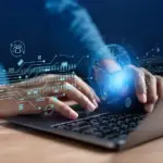 Hands of a man typing on the keyboard with technology icons in the shape of holograms floating above it.
