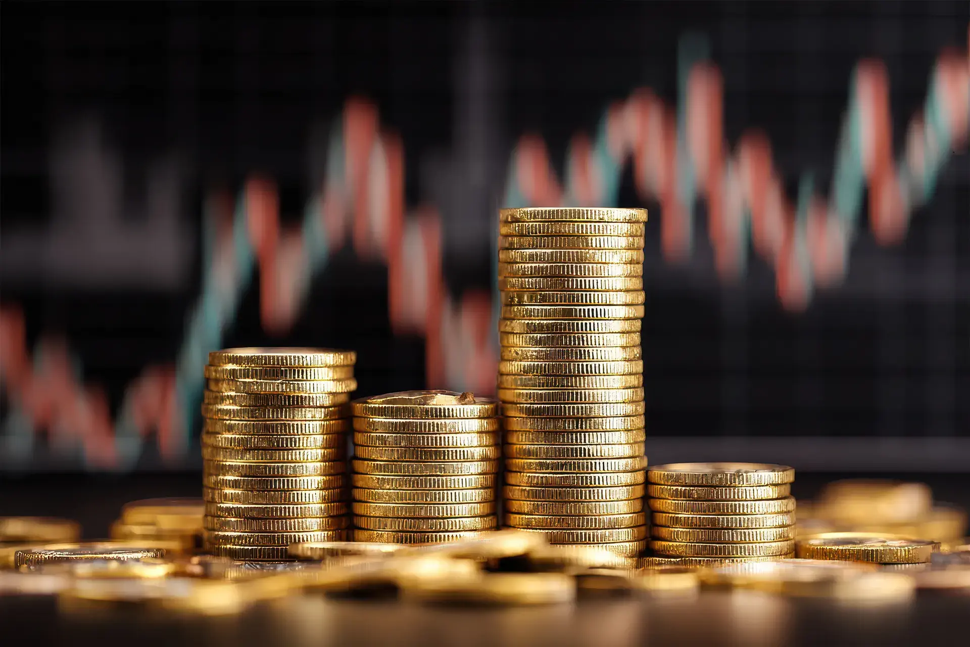 Gold coins stacked against a background wall of a financial chart
